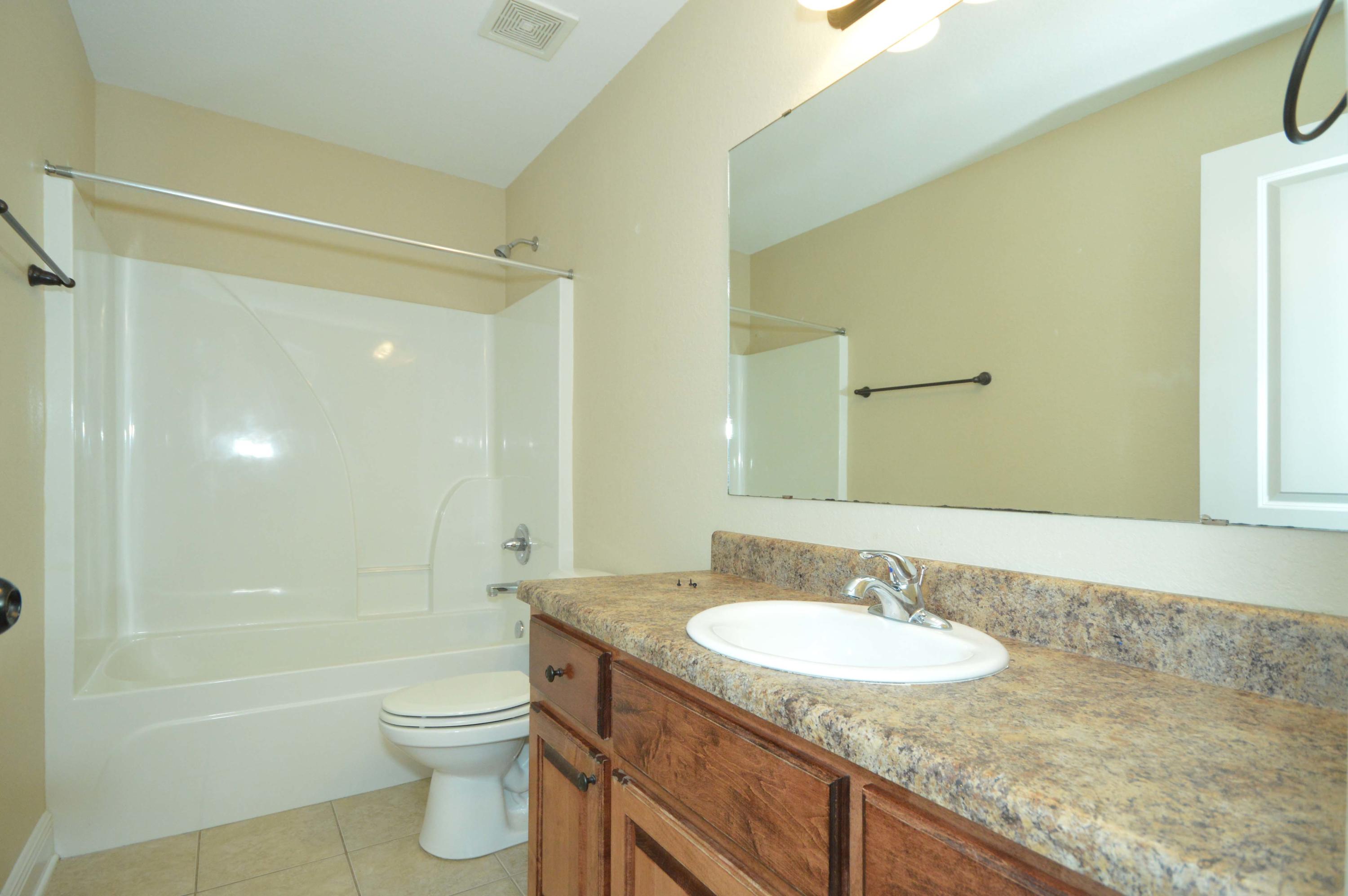 9970 Nichols Lake Road Milton, FL 32583 - Photo 33 of 48 a bathroom with a granite countertop sink toilet and shower