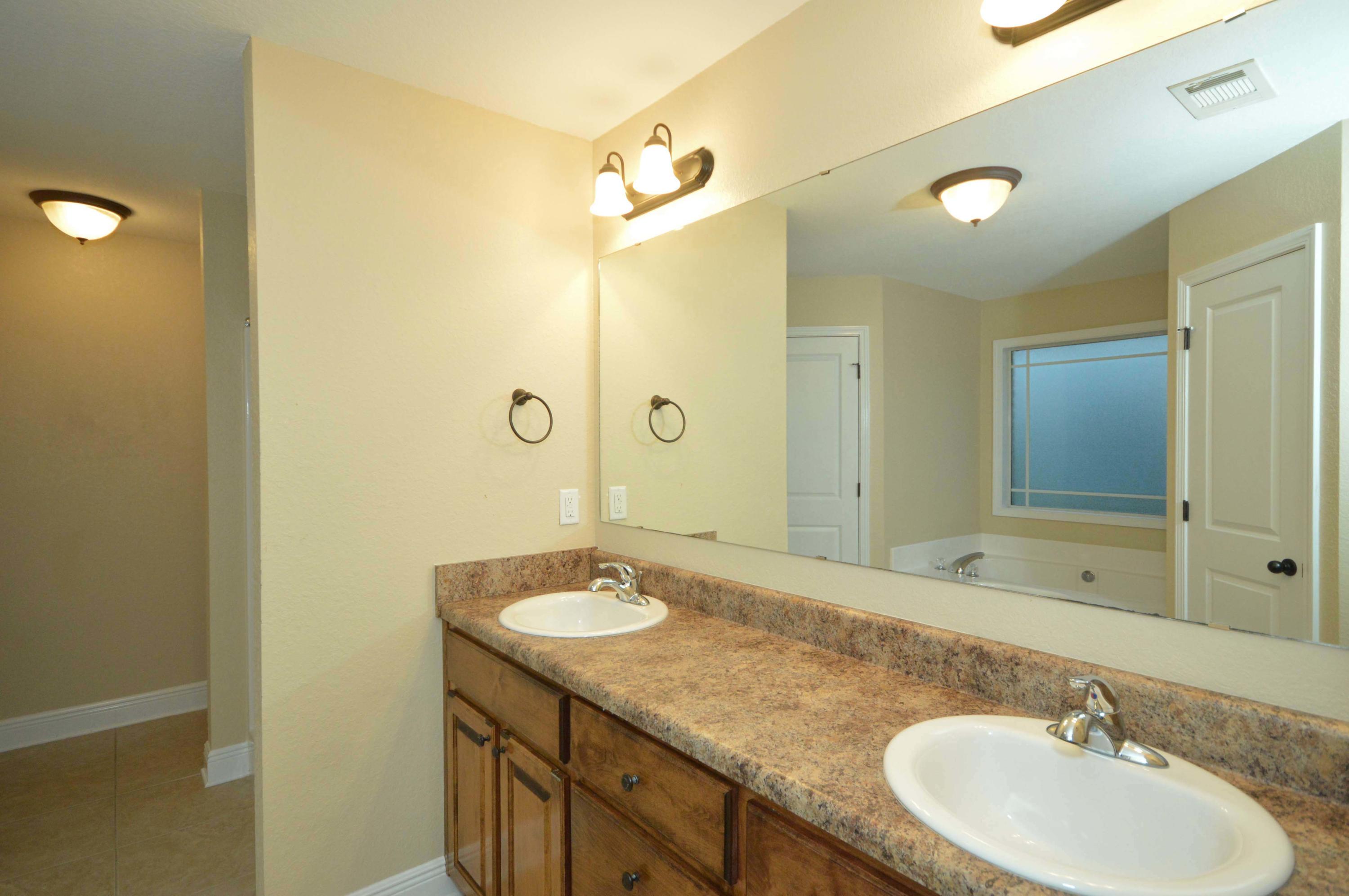 9970 Nichols Lake Road Milton, FL 32583 - Photo 39 of 48 a bathroom with a granite countertop sink and a mirror