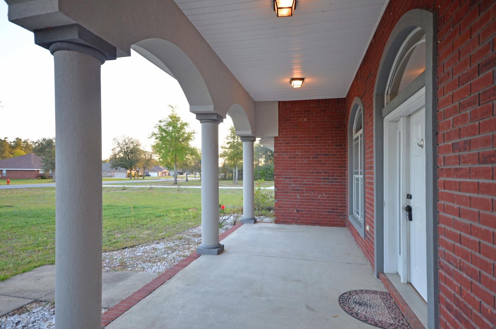 9970 Nichols Lake Road Milton, FL 32583 - Photo 4 of 48 a view of a porch with a big yard and potted plants