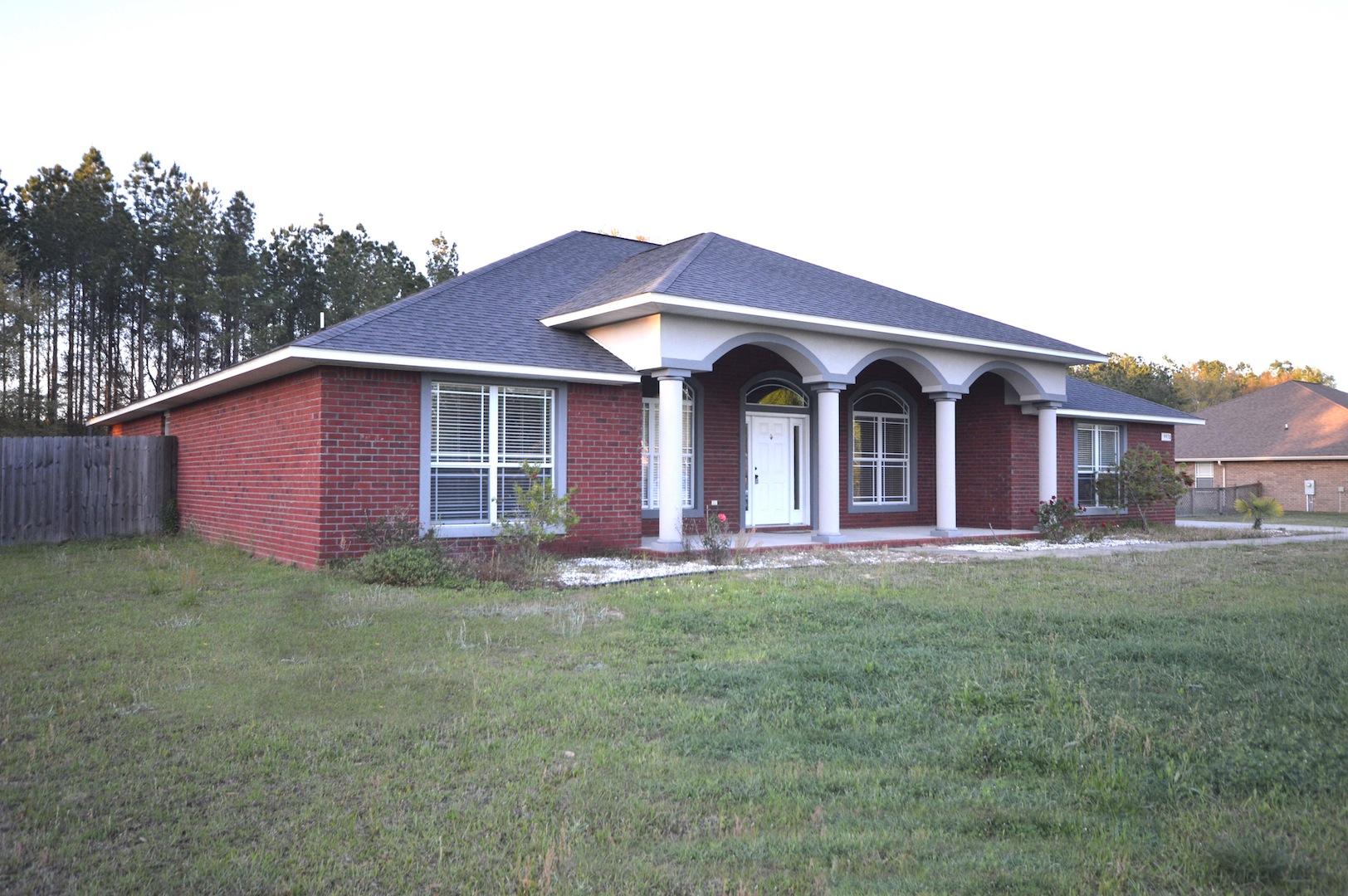 9970 Nichols Lake Road Milton, FL 32583 - Photo 5 of 48 a front view of a house with a garden