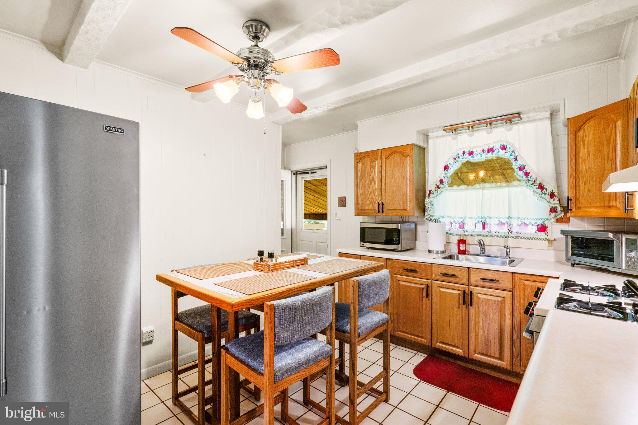 1814 Tyler Road Dundalk, MD 21222 - Photo 7 of 30 a kitchen with a table chairs and a refrigerator