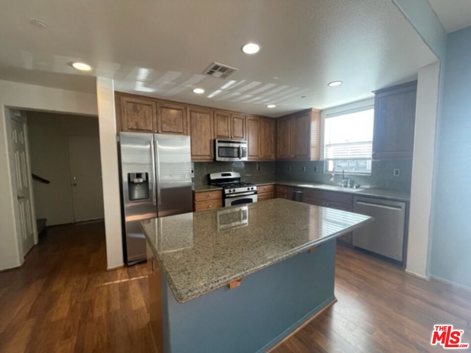20427 Paseo Azul Porter Ranch, CA 91326 - Photo 23 of 38 a large kitchen with stainless steel appliances granite countertop a sink a stove a refrigerator and island