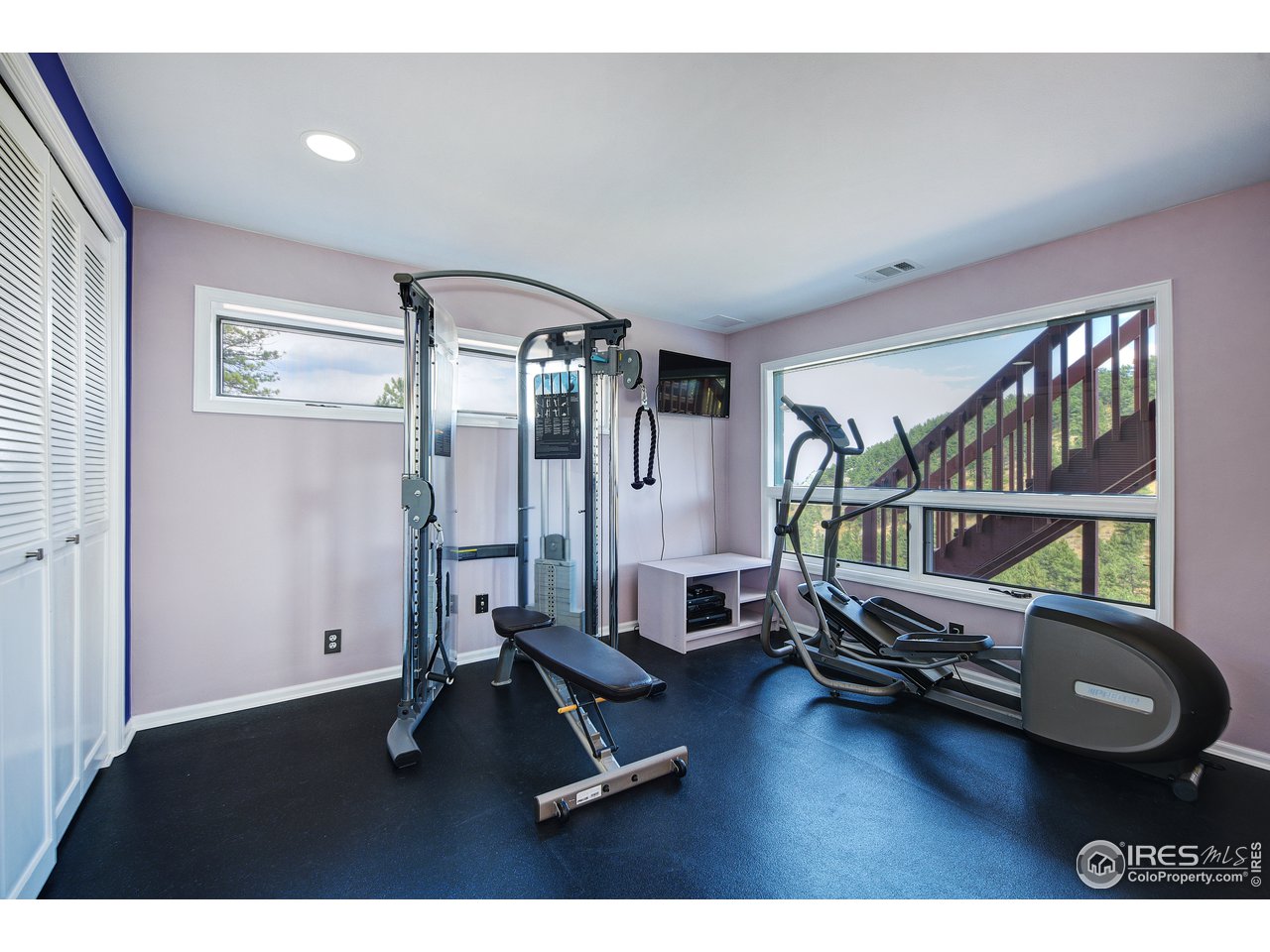 635 North Cedar Brook Road Boulder, CO 80304 - Photo 27 of 39 a living room with furniture gym equipment and a large window
