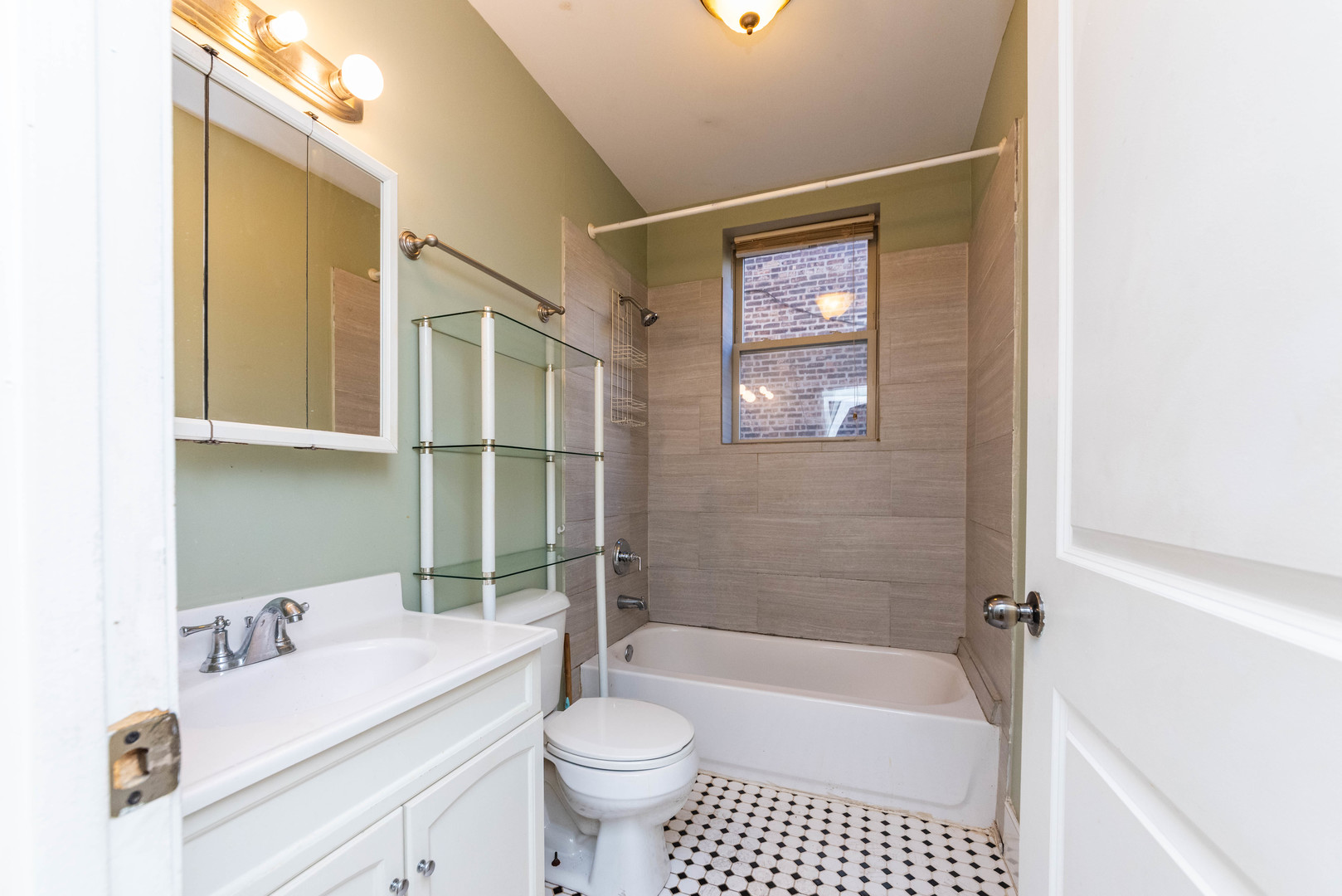 2812 East 76th Street, Unit 3 Chicago, IL 60649 - Photo 16 of 21 a bathroom with a sink a toilet a mirror a bathtub and shower