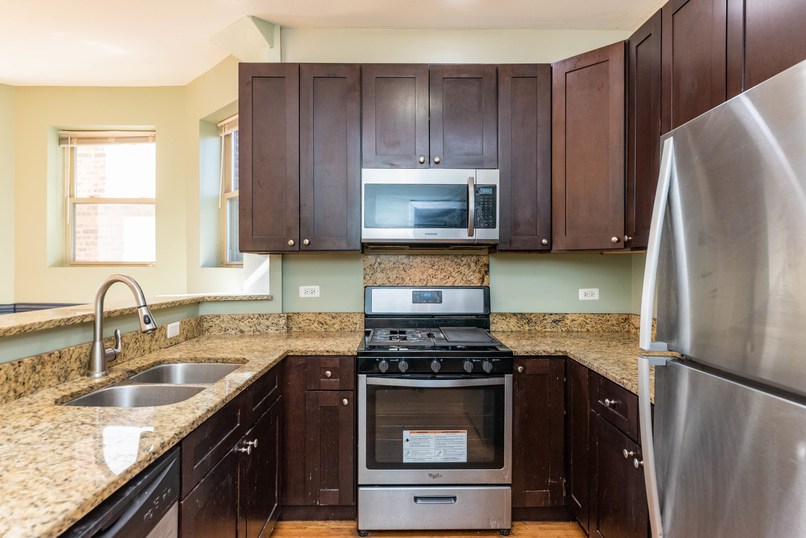 2812 East 76th Street, Unit 3 Chicago, IL 60649 - Photo 7 of 21 a kitchen with granite countertop a refrigerator stove and microwave