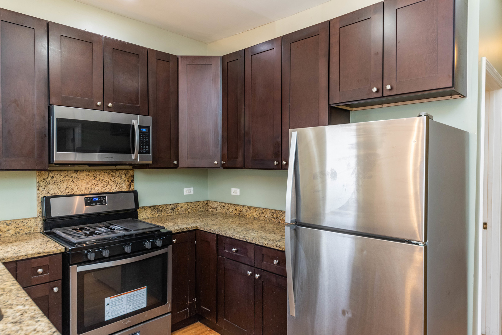 2812 East 76th Street, Unit 3 Chicago, IL 60649 - Photo 8 of 21 a kitchen with a stove microwave and refrigerator
