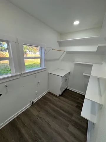 en empty room with wooden floor and windows