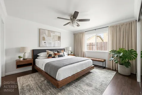 a bedroom with a large bed and a potted plant