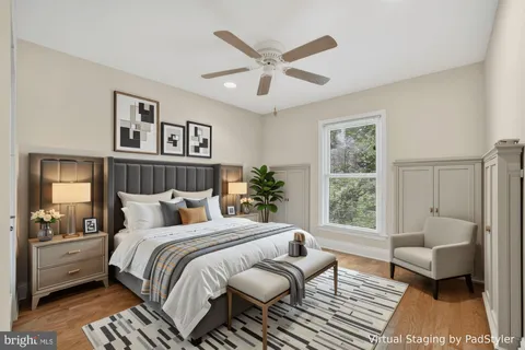 a bedroom with a large bed couch and a window