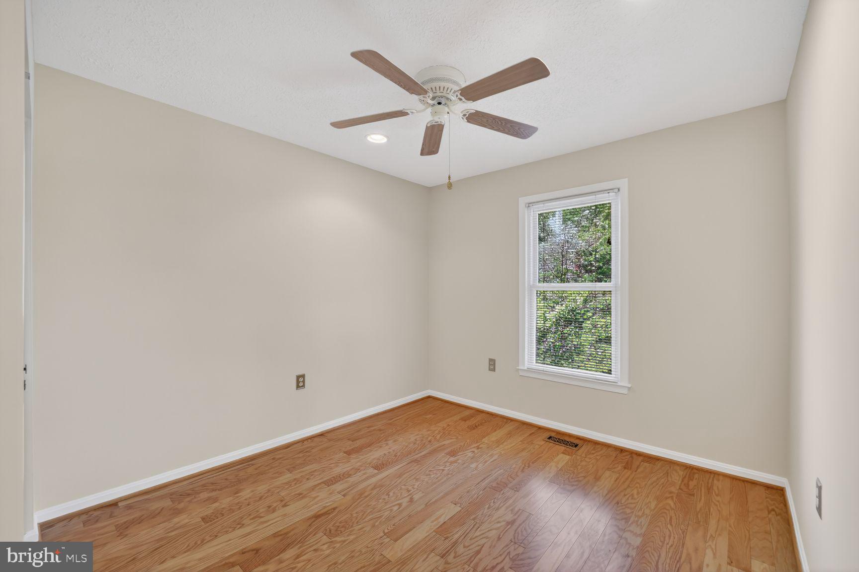 7265 Kousa Lane Springfield, VA 22152 - Photo 20 of 50 an empty room with wooden floor fan and windows