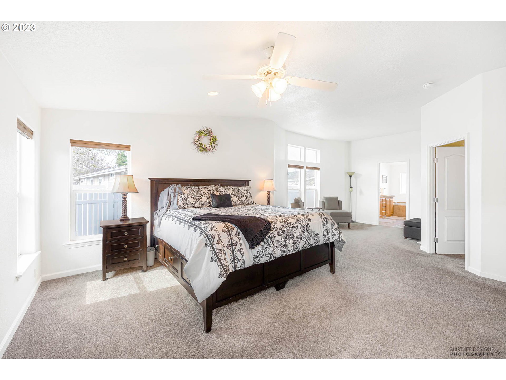 2458 Blue Boy Lane Eugene, OR 97404 - Photo 14 of 28 a spacious bedroom with a bed and a chandelier