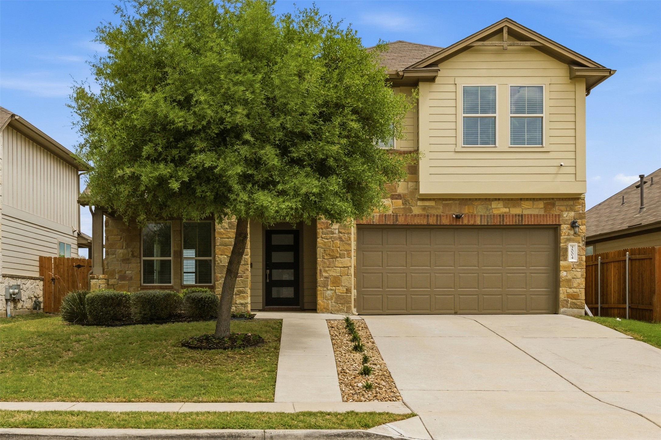 2004 Garretts Way Manchaca, TX 78652 - Photo 1 of 37 View of front of house featuring stone siding, concrete driveway, and a garage