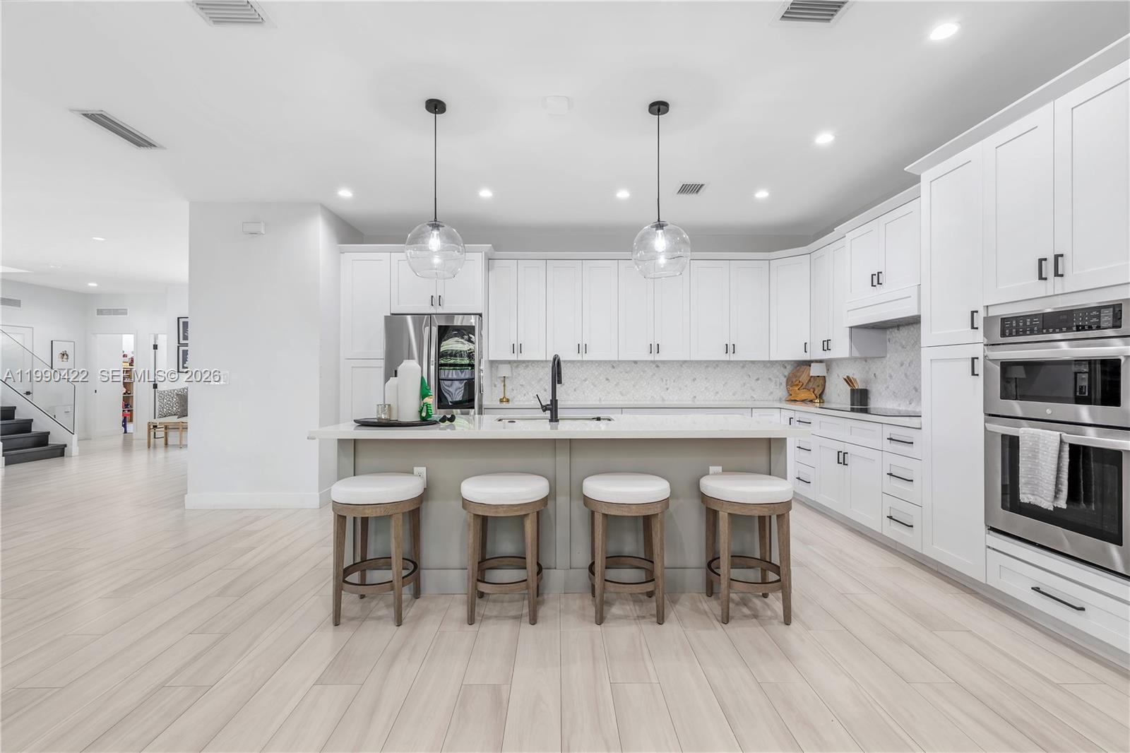 2775 Southwest 101st Court Miami, FL 33165 - Photo 11 of 46 a kitchen with stainless steel appliances a dining table chairs stove and cabinets