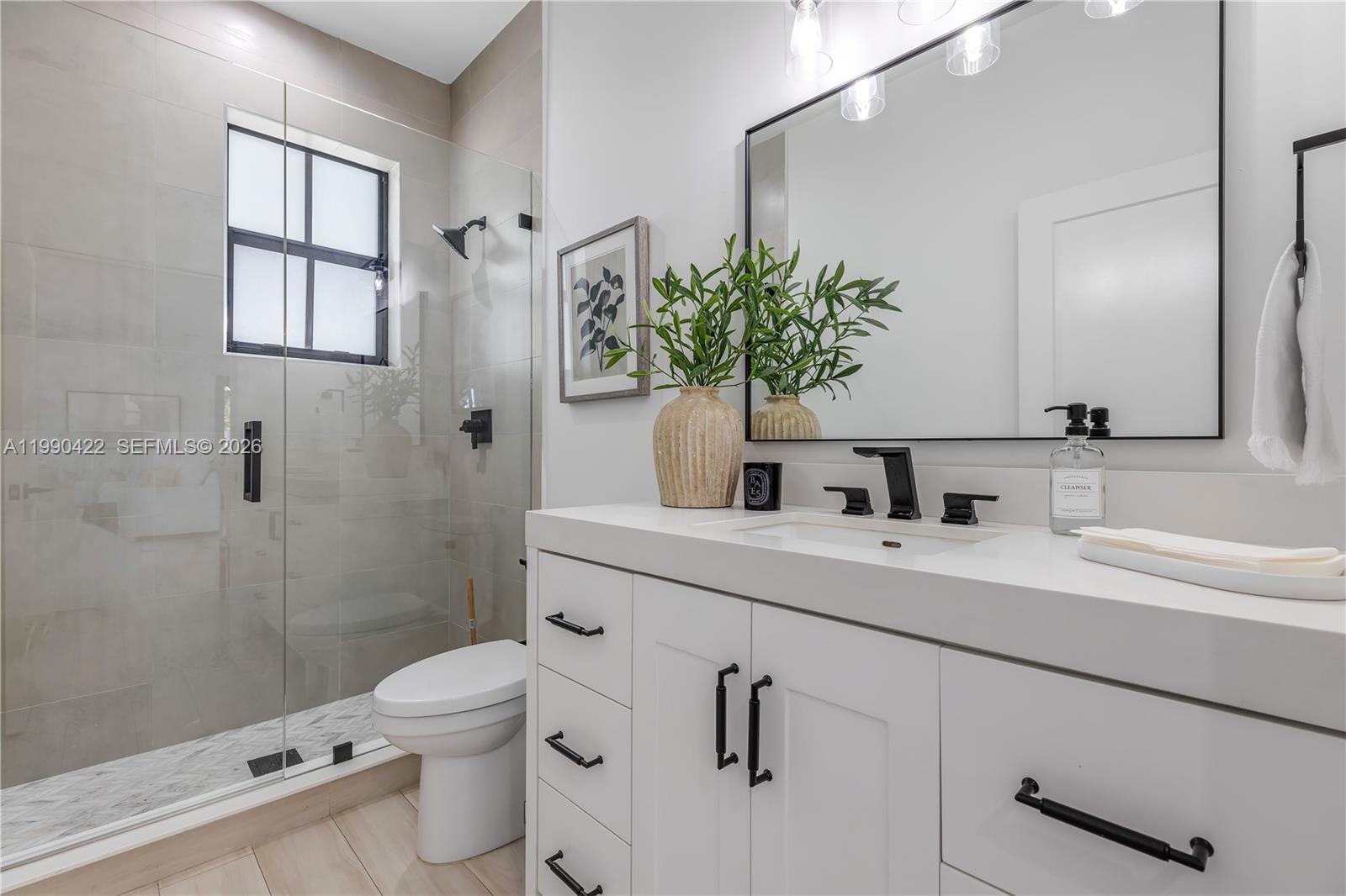2775 Southwest 101st Court Miami, FL 33165 - Photo 14 of 46 a bathroom with a sink a mirror a toilet and shower