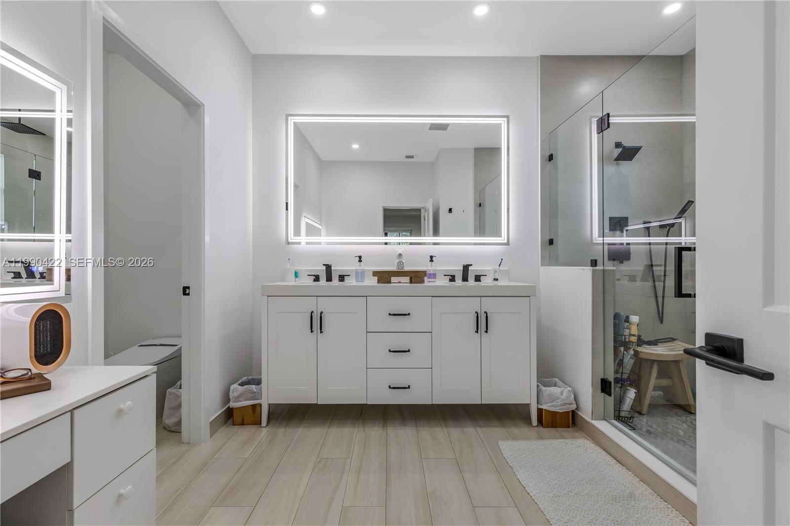 2775 Southwest 101st Court Miami, FL 33165 - Photo 30 of 46 a spacious bathroom with a double vanity sink a mirror a vanity and a bathtub