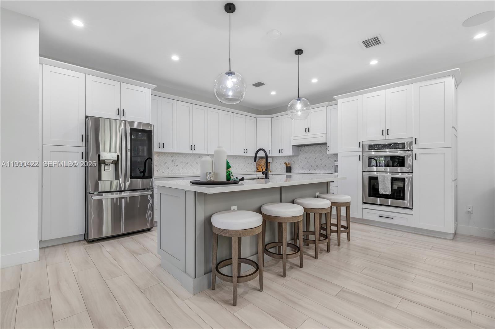 2775 Southwest 101st Court Miami, FL 33165 - Photo 10 of 46 a kitchen with refrigerator a stove a sink and chairs