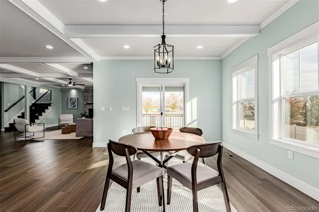 a dining room with wooden floor and a chandelier