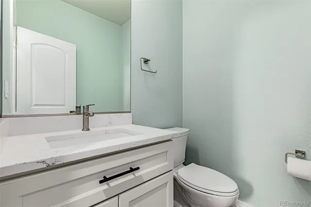 a bathroom with a sink a toilet and mirror