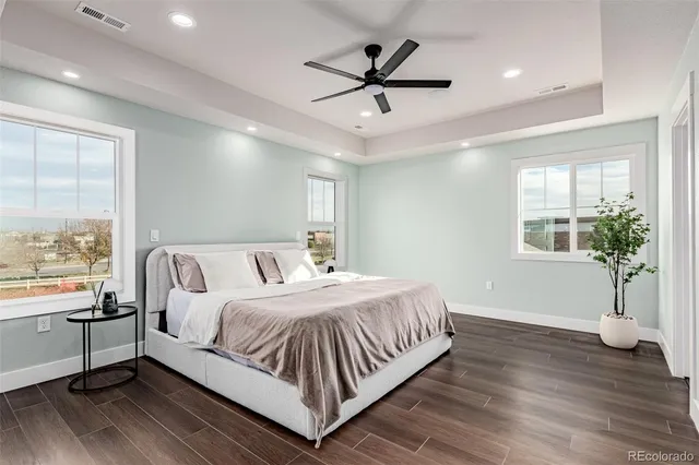a bedroom with a large bed chandelier and a window
