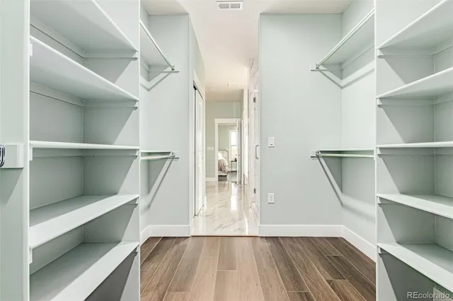 a view of walk in closet with wooden floor