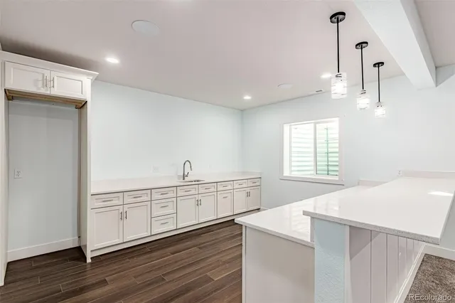 a kitchen with granite countertop white cabinets and white appliances