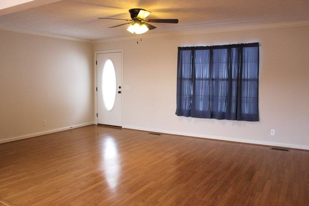 803 Red Hollow Drive Springfield, TN 37172 - Photo 4 of 9 an empty room with wooden floor chandelier fan and windows