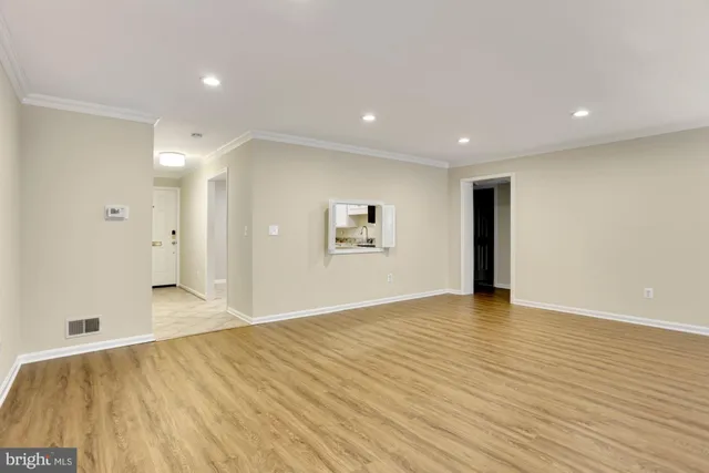 a view of an empty room with wooden floor