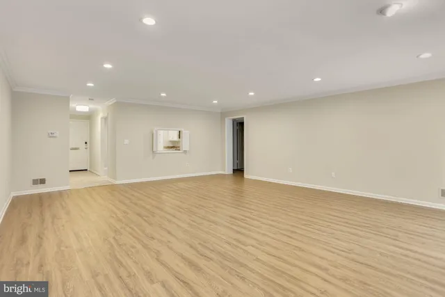 a view of an empty room with wooden floor
