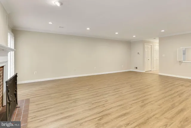 an empty room with wooden floor and a fireplace