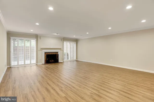 an empty room with wooden floor and fireplace