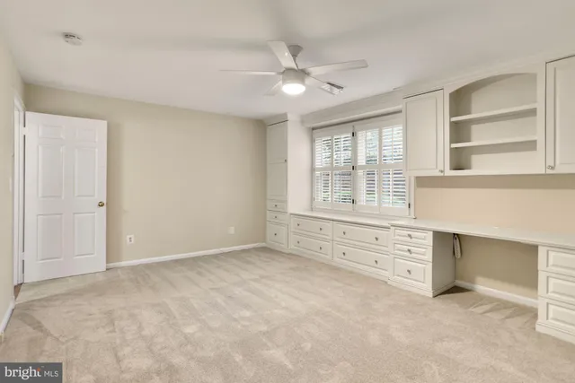 an empty room with windows and cabinet
