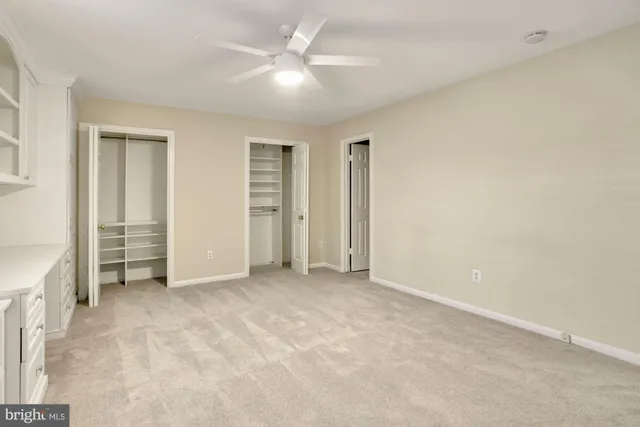 an empty room with closet and a ceiling fan