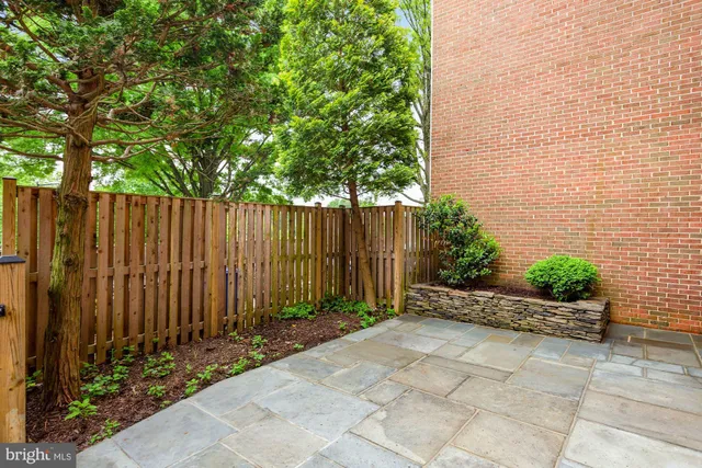 a view of backyard with potted plants and wooden fence