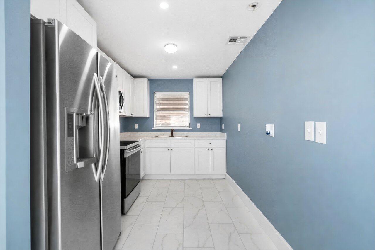 3527 Kirk Road Lake Worth, FL 33461 - Photo 16 of 25 a kitchen with a refrigerator sink and cabinets
