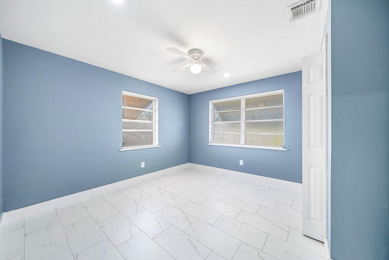 3527 Kirk Road Lake Worth, FL 33461 - Photo 18 of 25 a bedroom with a bed and a window