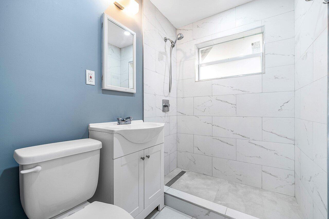 3527 Kirk Road Lake Worth, FL 33461 - Photo 20 of 25 a bathroom with a toilet sink and mirror