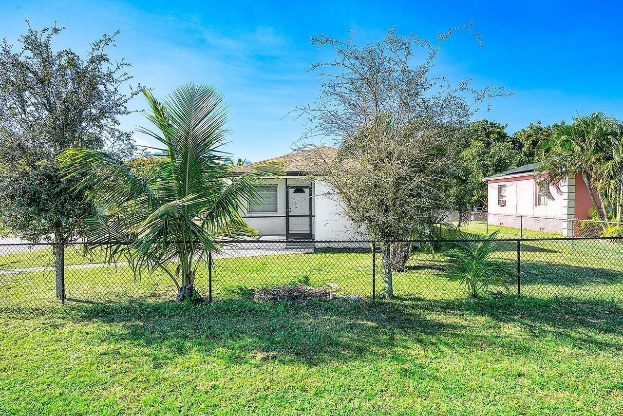 3527 Kirk Road Lake Worth, FL 33461 - Photo 3 of 25 a view of a house with a big yard and palm trees