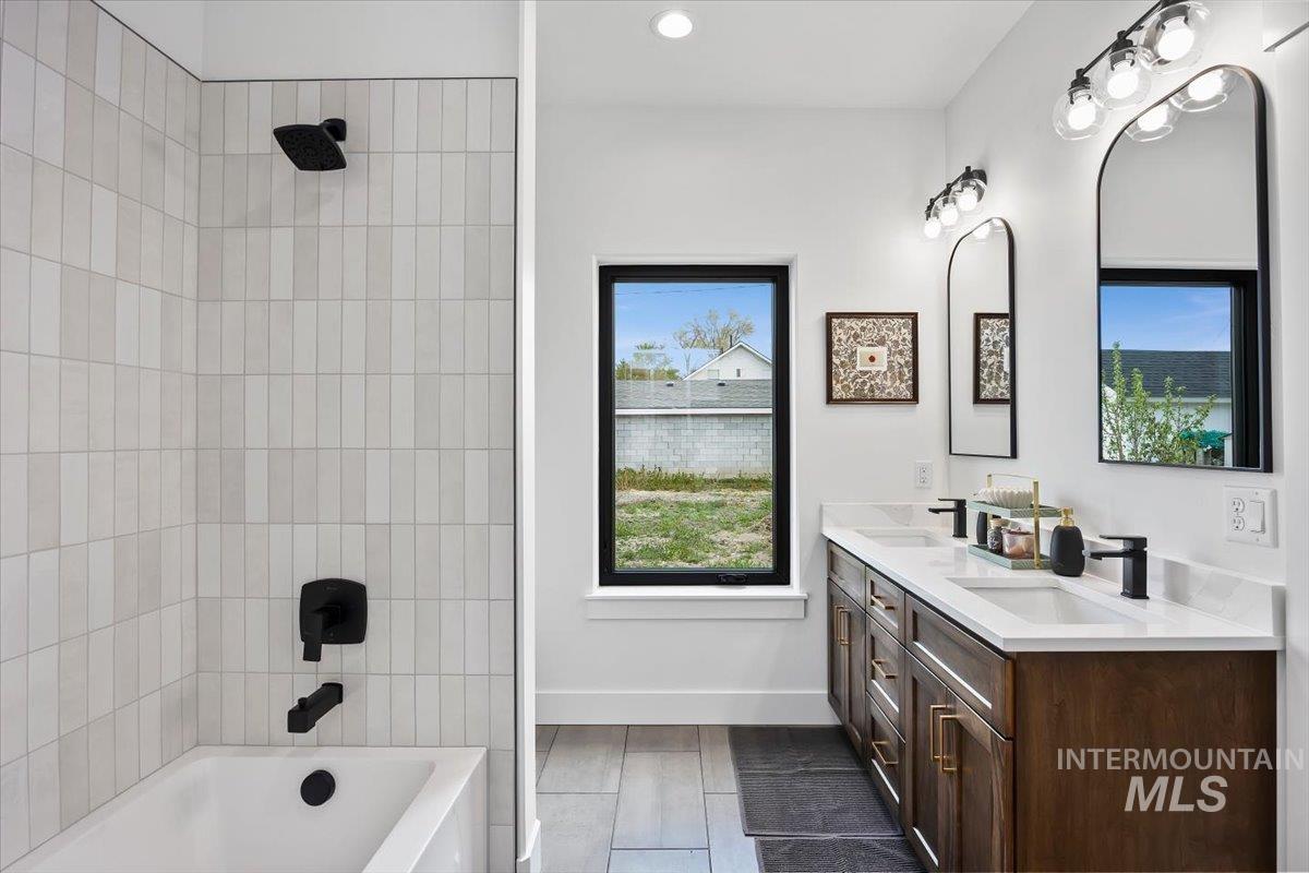 107 3rd Street West Declo, ID 83323 - Photo 17 of 25 Contemporary bathroom featuring a double vanity with wood-finish cabinetry, white countertops, and matte black fixtures