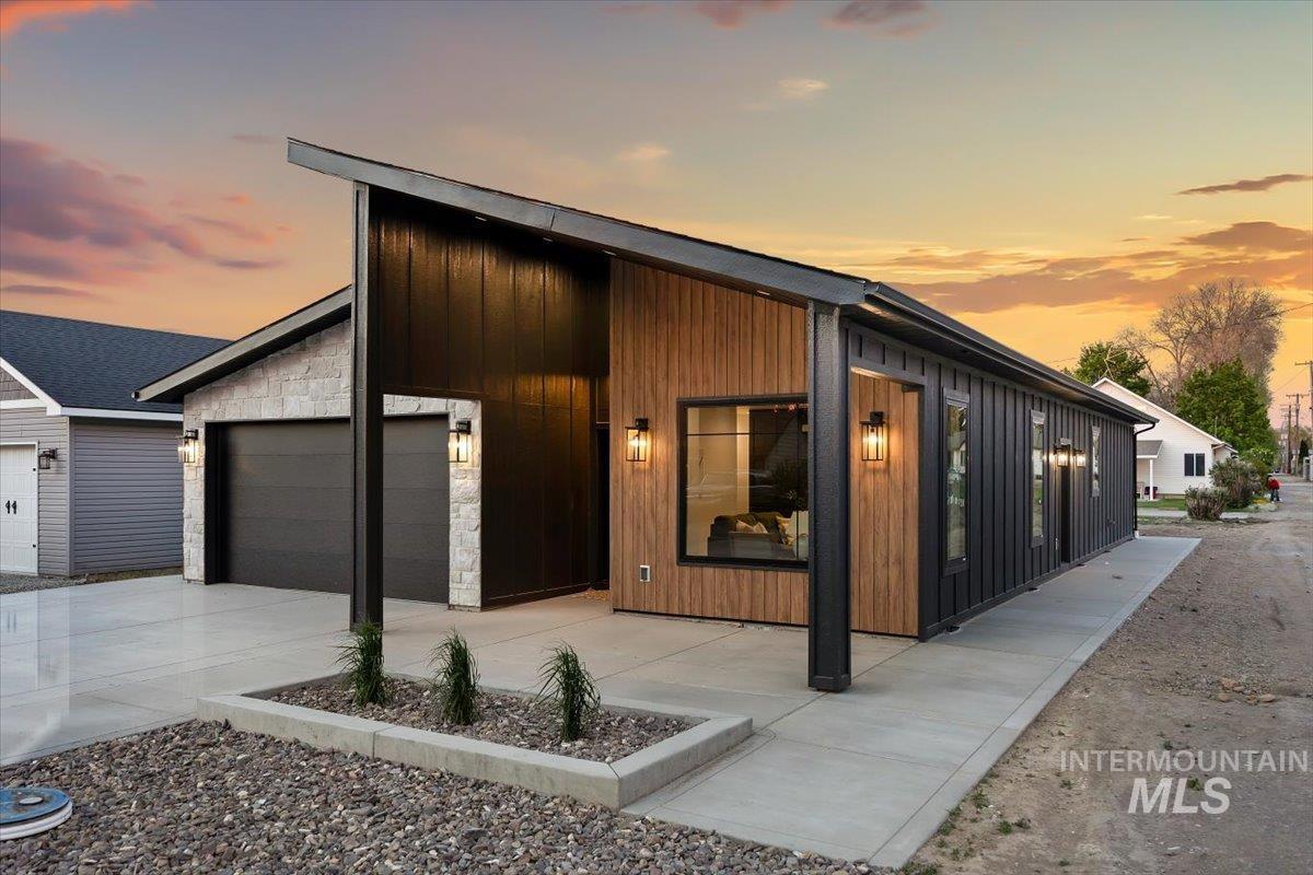 107 3rd Street West Declo, ID 83323 - Photo 24 of 29 Contemporary exterior featuring wood-finish siding, dark vertical paneling, and light stone accents