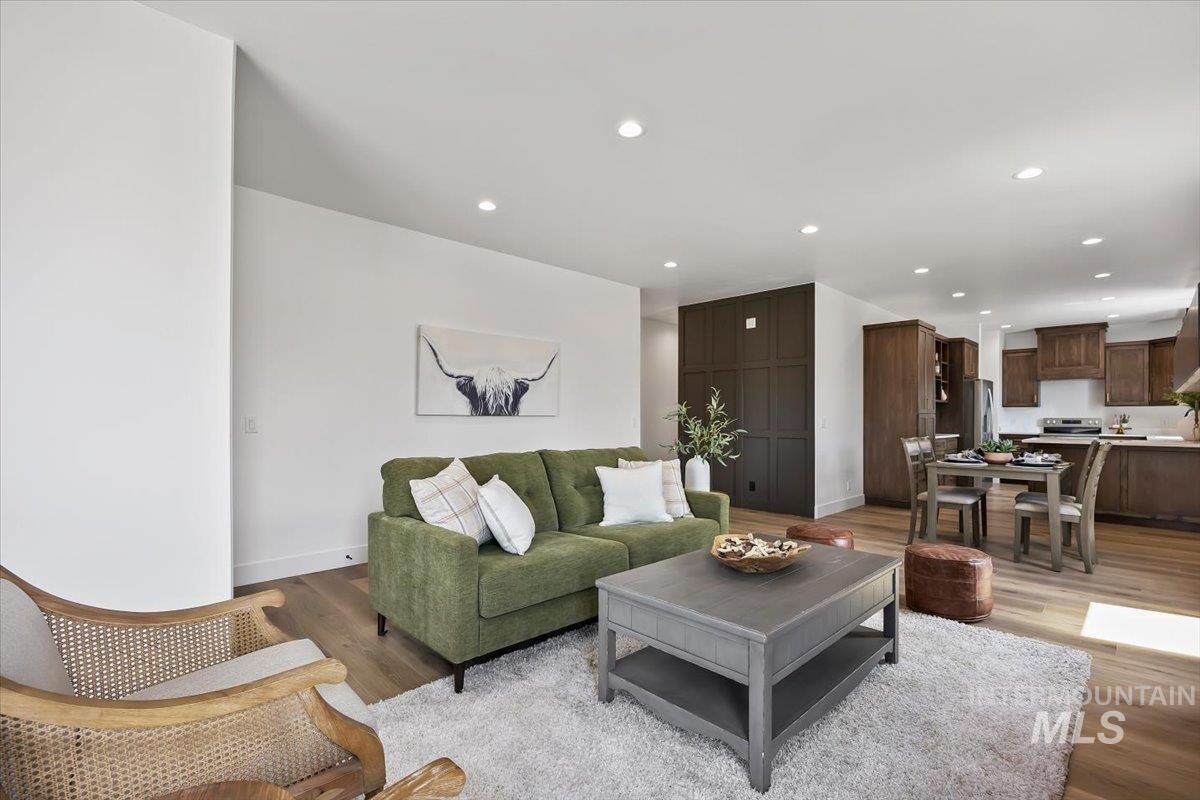 107 3rd Street West Declo, ID 83323 - Photo 3 of 25 Open-concept living area featuring wood-finish flooring, recessed lighting, and a dark wood panel accent wall