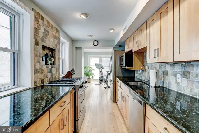 a kitchen with granite countertop a sink a counter top space appliances and cabinets