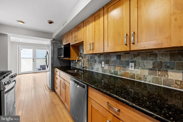 a kitchen with stainless steel appliances a stove a sink and a microwave