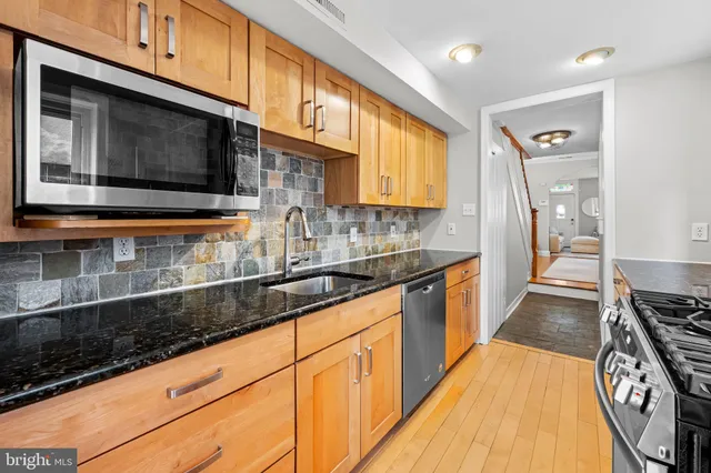a kitchen with stainless steel appliances granite countertop a stove and a refrigerator