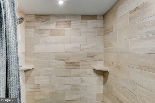 an empty room with an entryway and chandelier fan