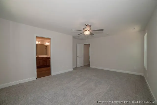 an empty room with chandelier fan