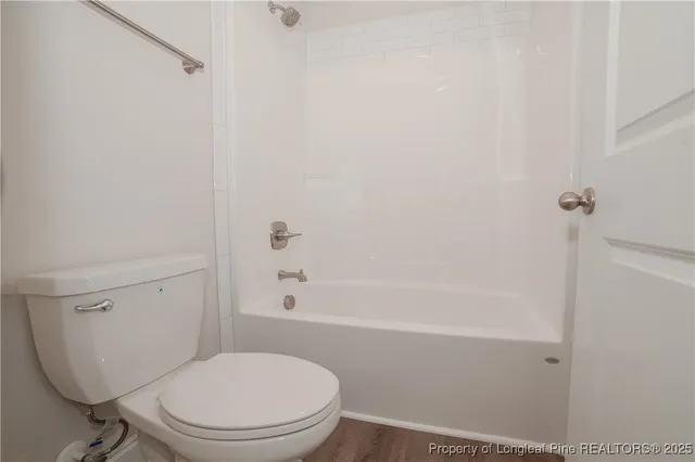 a white toilet sitting next to a bath tub