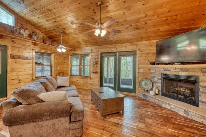 130 Coopers Ridge Road Murphy, NC 28906 - Photo 12 of 32 a living room with furniture a flat screen tv and a fireplace