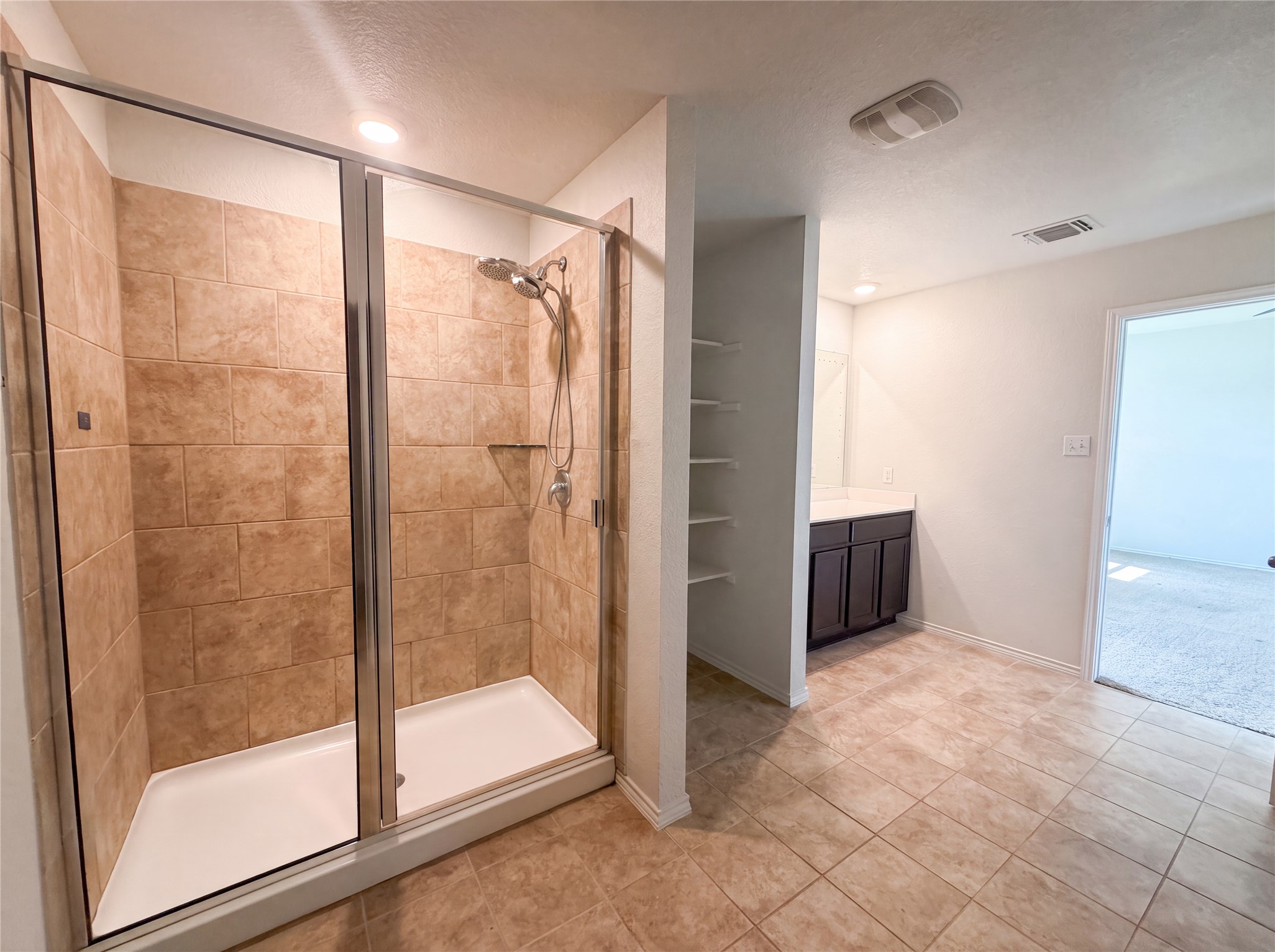233 Atwood Loop Jarrell, TX 76537 - Photo 12 of 15 Tiled flooring and a spacious walk-in shower define this functional bathroom layout.