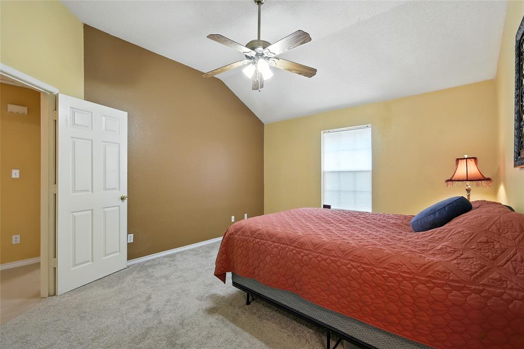 4609 Hunters Ridge Drive Sachse, TX 75048 - Photo 15 of 38 a bedroom with a bed and a chandelier