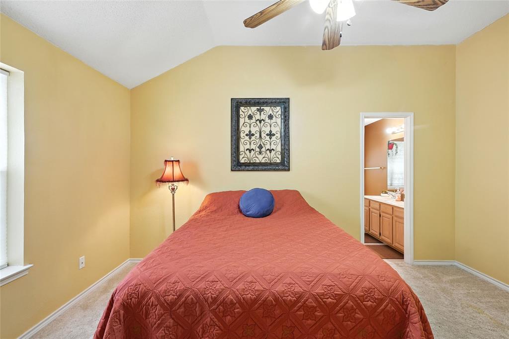 4609 Hunters Ridge Drive Sachse, TX 75048 - Photo 17 of 38 a bedroom with a bed and a chandelier